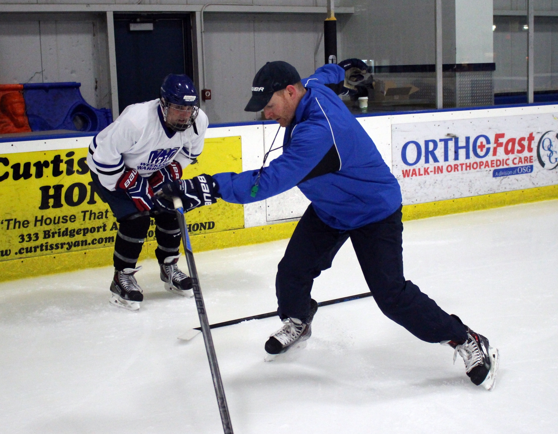 Coach Casey helps a player with his skating stride