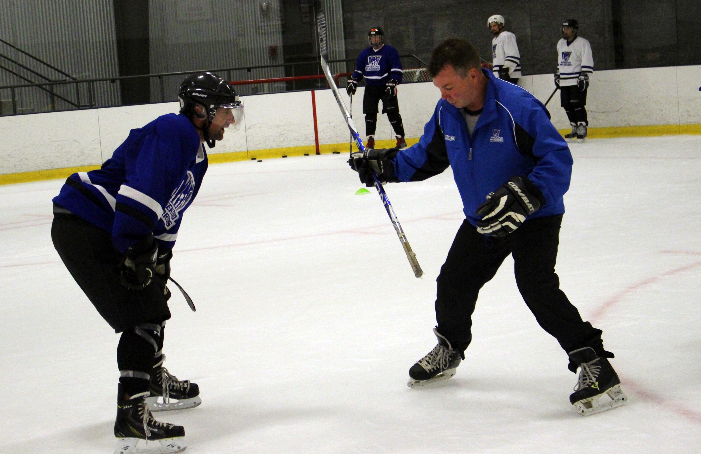 Coach Kevin helps player with wrist shot