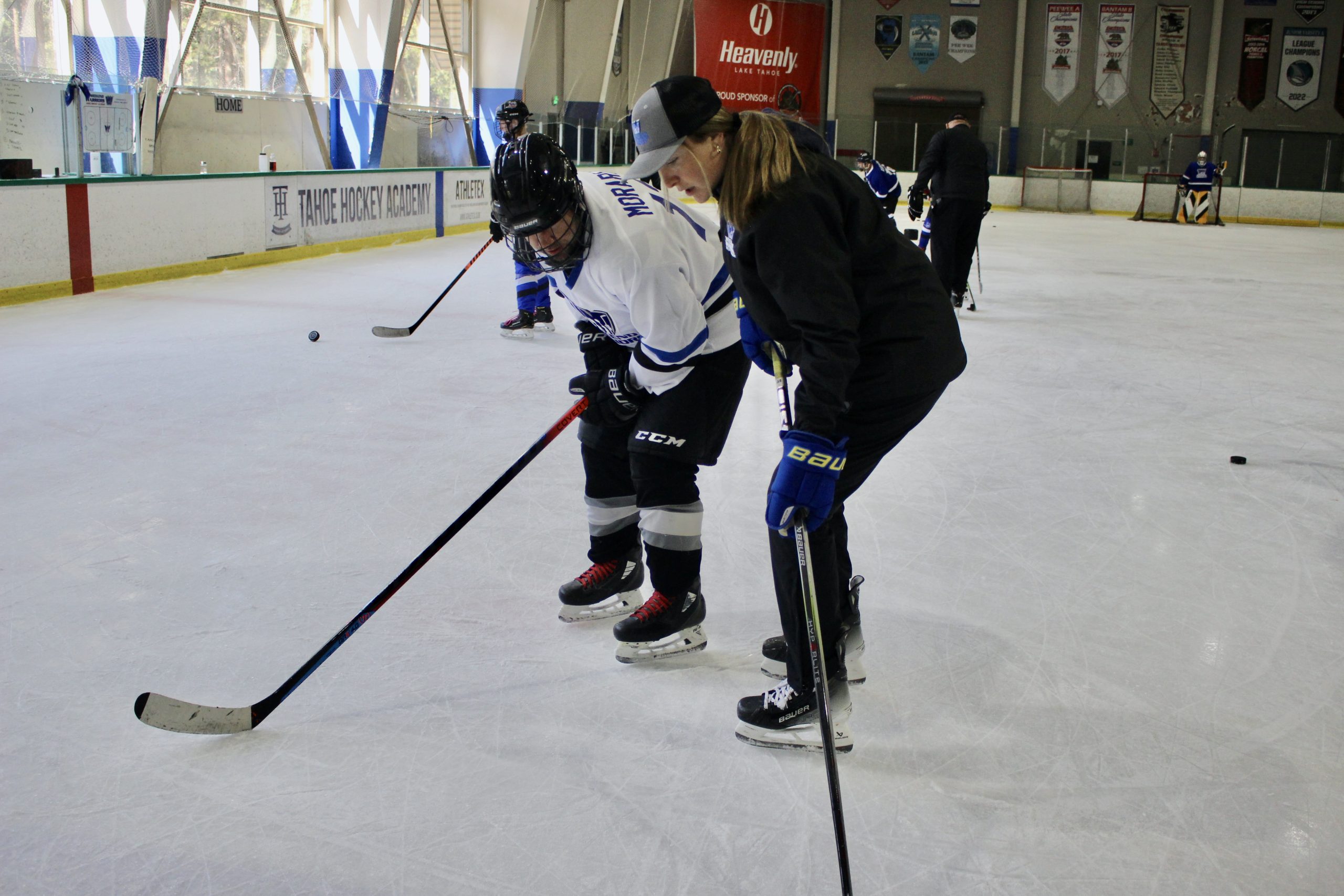 Coach Leah helps player with his wrist shot