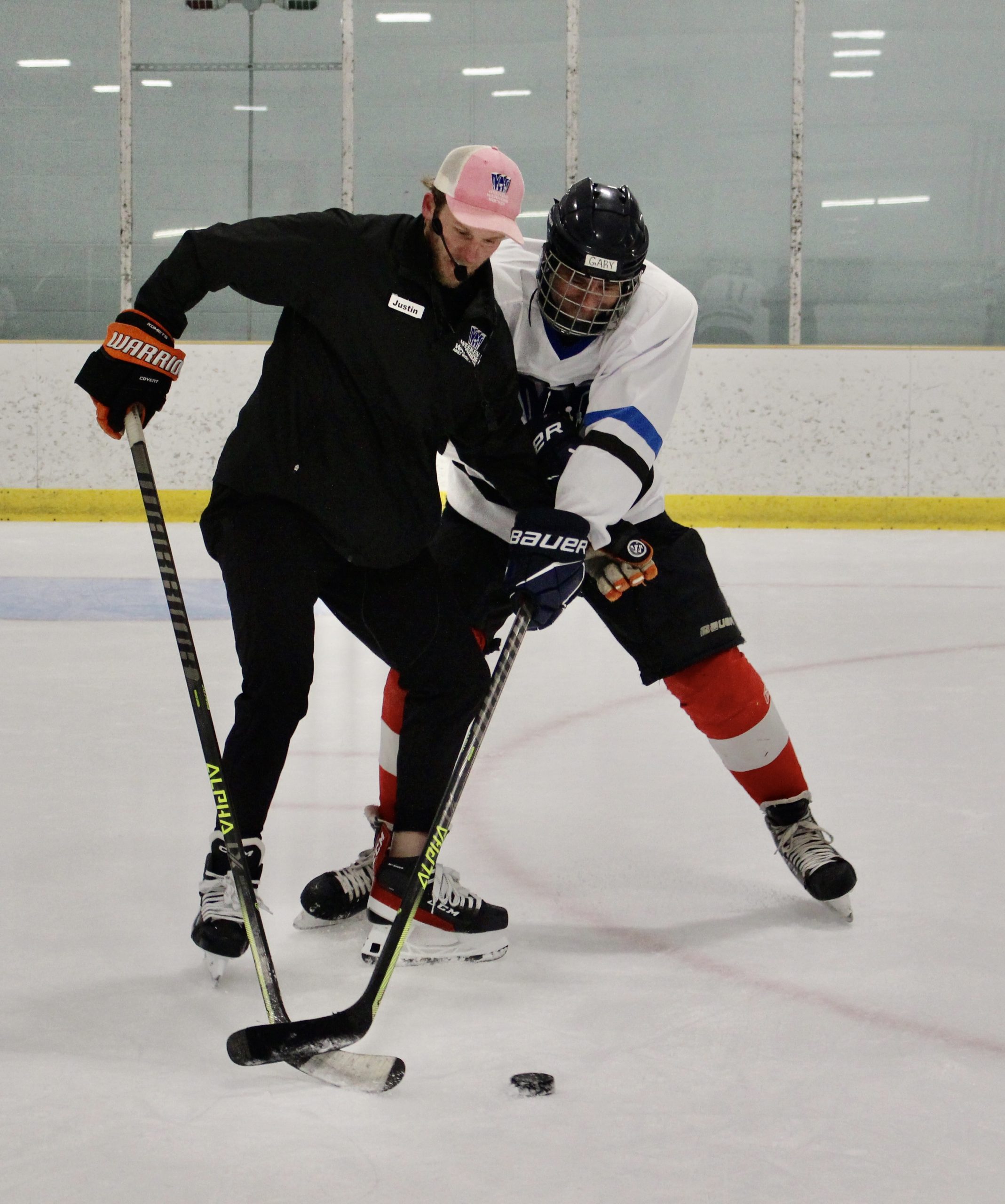 Coach Justin in a puck protection drill with a camper